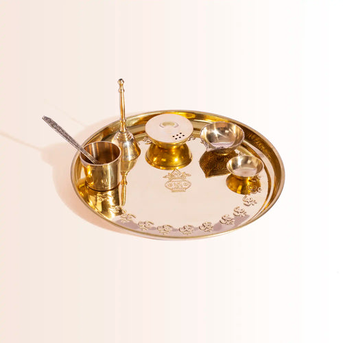 Gold tray with various utensils on a beige background